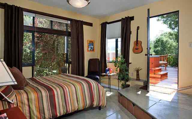 Bedroom opening to a private deck and trees