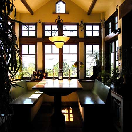 Built-in banquette under a clerestory with mullioned windows on three sides