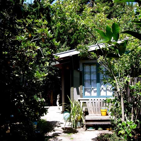 Painted garden cabin tucked among magnolia and citrus